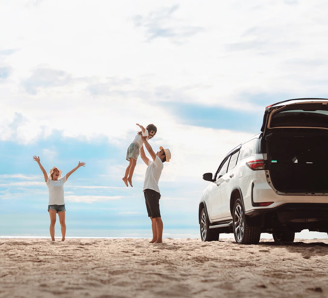 浜辺で遊ぶ家族の写真。安心と信頼のモビリティ技術。