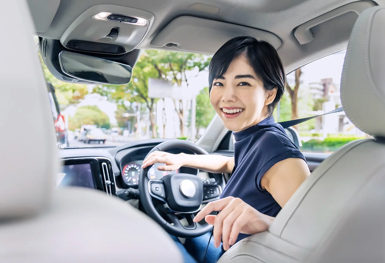 笑顔で振り返る車内の女性。安全で快適な走りを提供。